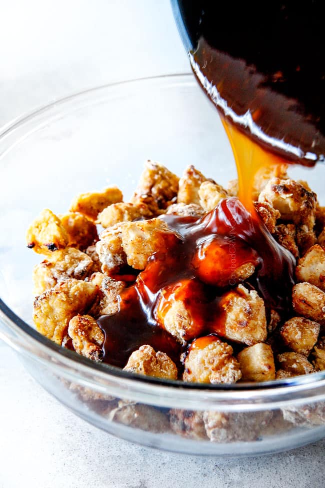 Pouring sauce over top the chicken for General Tso's Chicken.