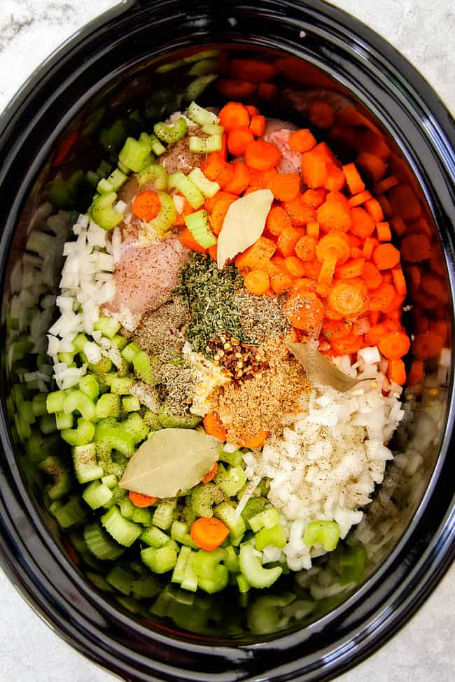 This is the BEST Slow Cooker Chicken Tortellini Soup you will ever try!ย It's super easy, seasoned to perfection and a comforting, satisfying dinner any night of the week!ย ย showing how to make Chicken Tortellini Soup by adding carrots, onions, celery, seasonings to a crock pot