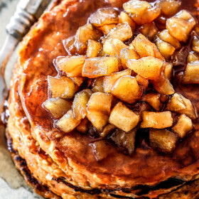up close view of chunky cinnamon apple syrup on top of a stack of sweet potato pancakes