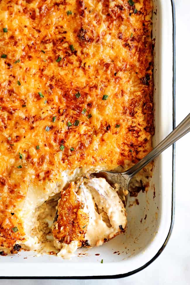 Top view of Scalloped Potatoes & Au Gratin with Bacon being served with a spoon.