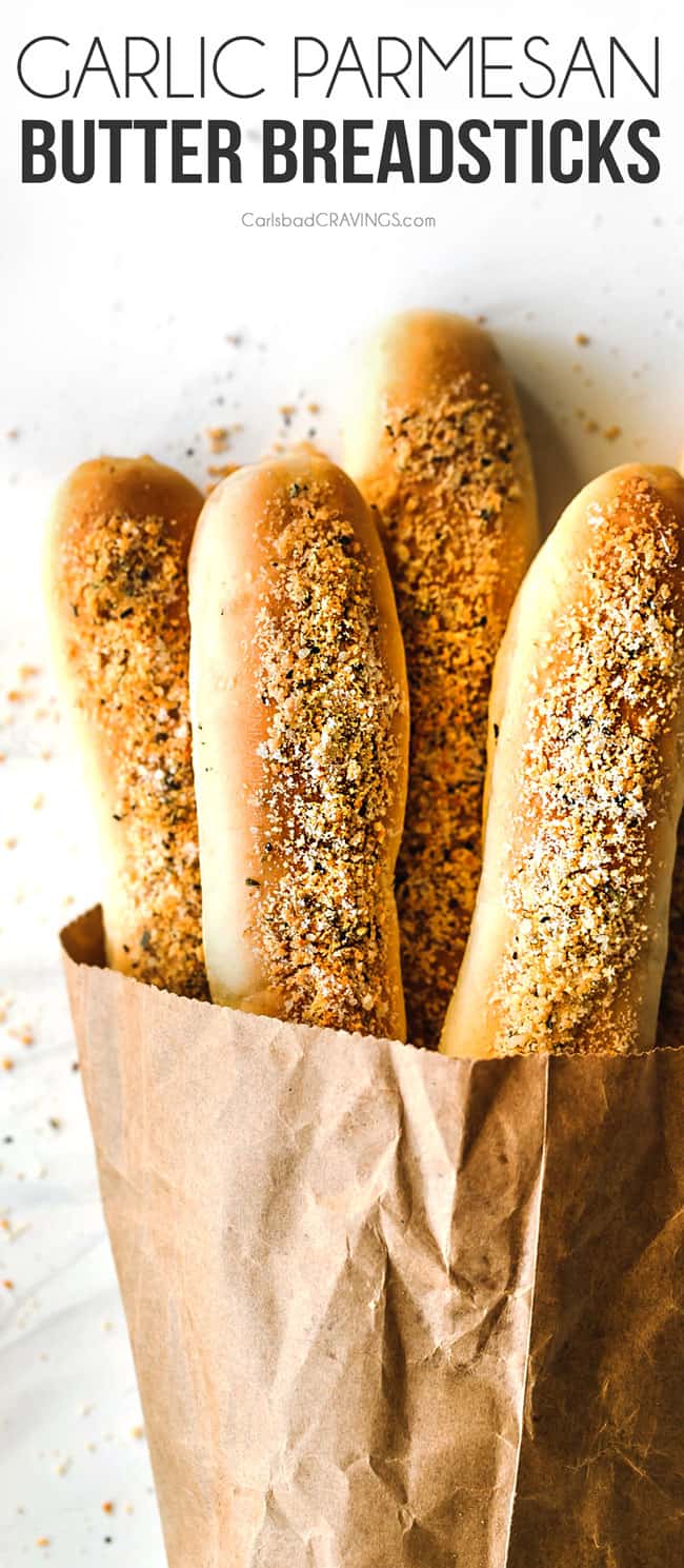 top view of Parmesan Garlic Breadsticks in a brown bag on a white marble counter