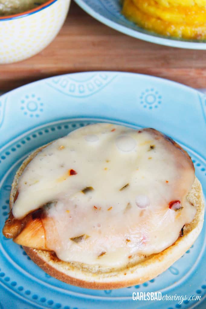 showing how to make Teriyaki Chicken Sandwiches by adding cheese to chicken