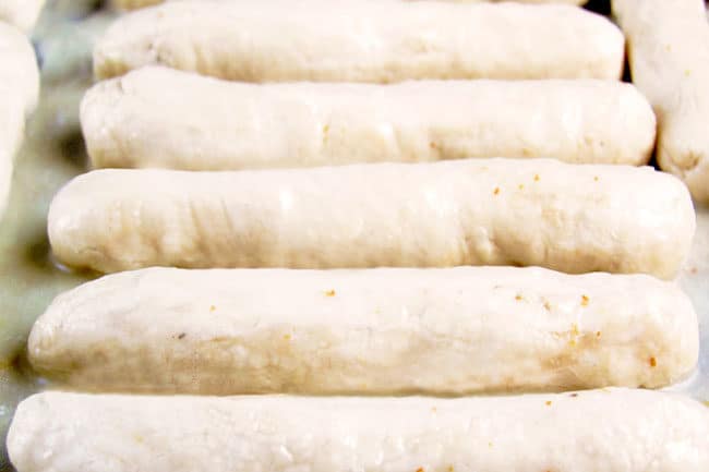 showing how to make garlic parmesan breadsticks by letting rolled breadsticks rise on a baking sheet