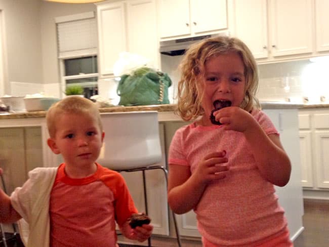 Chocolate Zucchini Muffins with DOUBLE the CHOCOLATE, ZERO added fat and a whole lot of yum!! This Chocolate Zucchini Muffins Recipe is baked with applesauce and vanilla yogurt that are crazy moist and chocolaty!ย You will devour these by the handfuls - becauseย you can! two children eating healthy Chocolate Zucchini Muffins