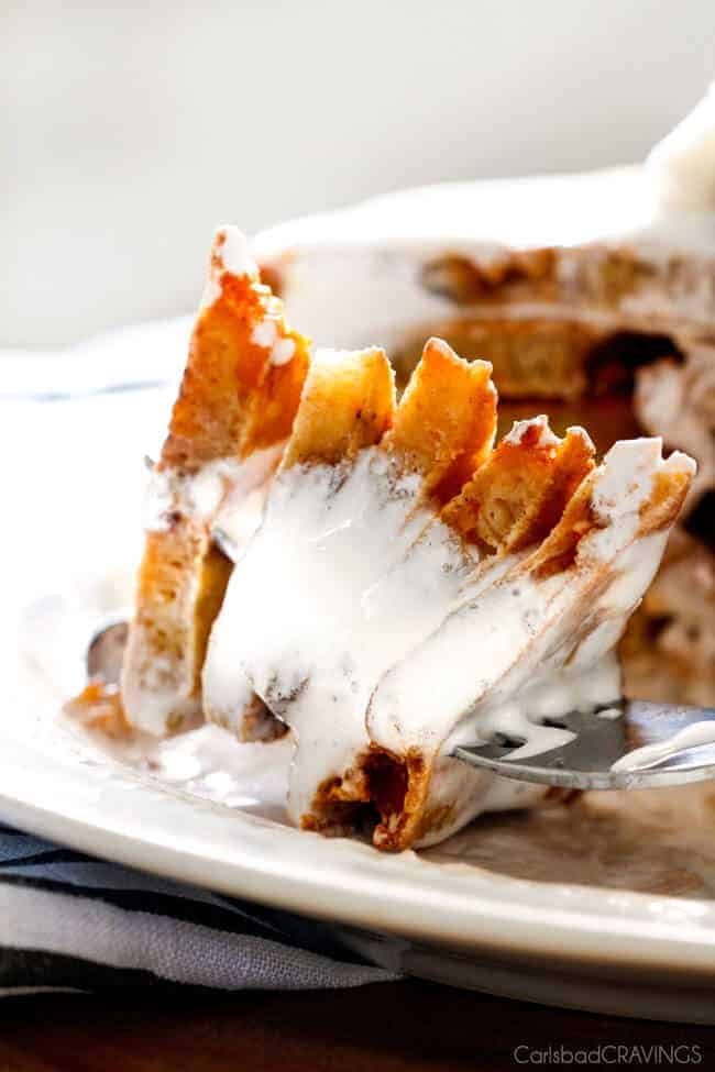 An extreme close up Fluffy S'mores Pancakes pouring marshmallow syrup over top.