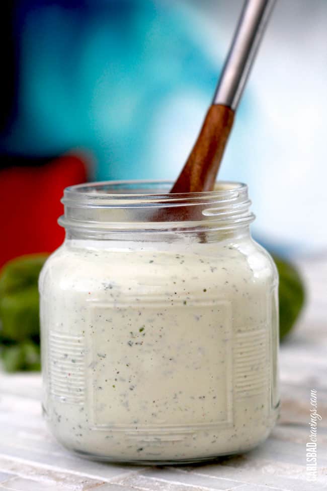 a wooden spoon in avocado lime ranch dressing