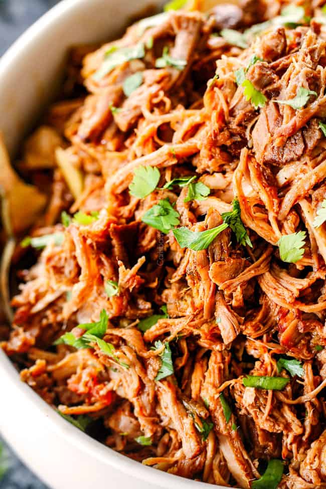 up close of chipotle sweet pulled pork in a white bowl with cilantro