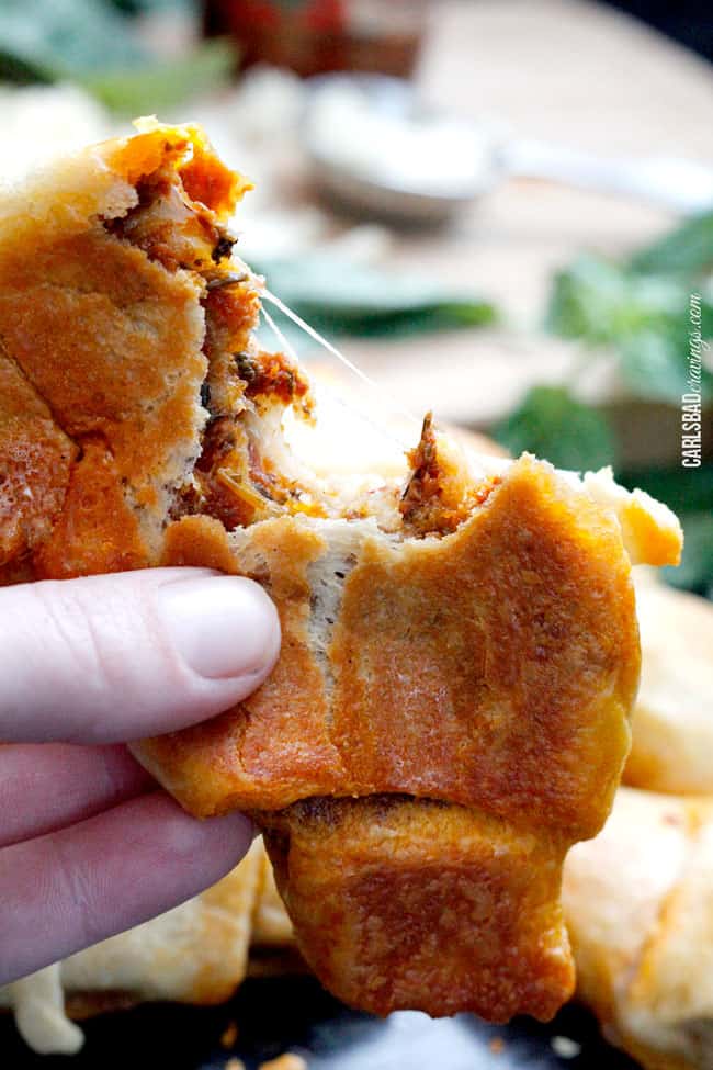 pulling a Pillsbury crescent roll in half with cheese