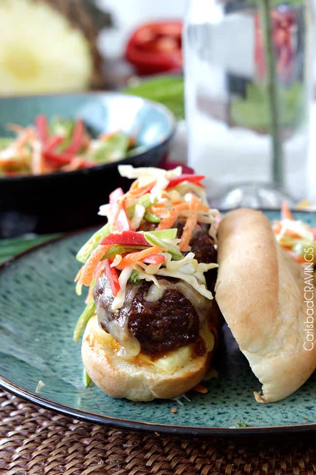 Aloha Subs are your favorite sweet, tangy, spicy Hawaiian flavors packed in a juicy sub sandwich! Theyโre spectacularly juicy and cheesy topped with crunchy snow pea slaw! showing how to make Aloha subs by piling with slaw