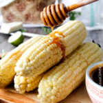 easy Roasted or grilled corn on the cob never tasted so delicious brushed with delectable Chipotle Honey Lime Butter sprinkled with cilantro and cotija cheese! Perfect for the 4th or roast year round. #corn #Mexicancorn #grilledcorn #chipotle