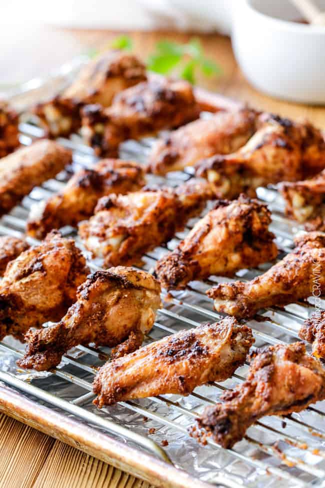 Showing how to make Baked Chipotle Honey Lime Hot Wings on a baking pan.