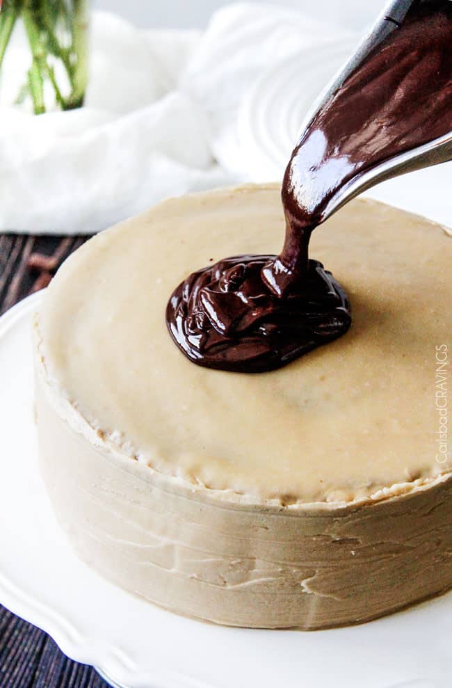 process shot showing chocolate ganache being poured on top of a chocolate cake with caramel frosting
