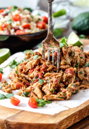 Easy Slow Cooker Shredded Mexican Chicken simmered with Mexican spices, salsa and green chilies for the BEST Mexican chicken perfect for tacos, burritos, tostadas, salads, etc. Couldnโt be any easier!