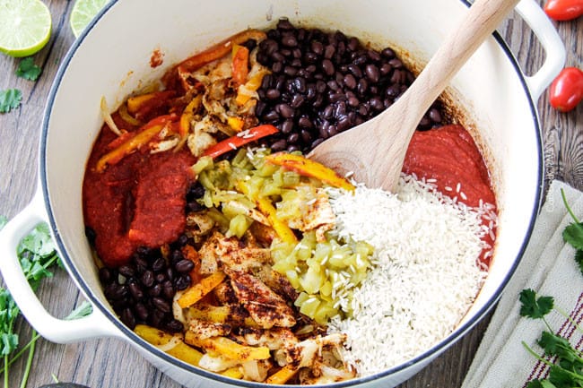 process shot showing how to make fajita soup by adding ingredients in a large Dutch oven