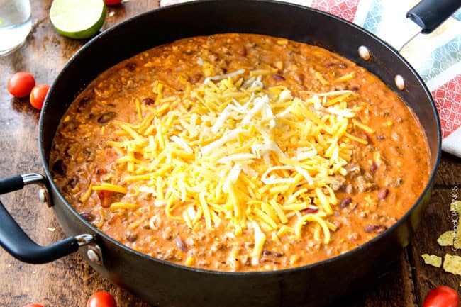 showing how to make cheesy taco pasta with cream cheese by melting cream cheese and cheese in a skillet