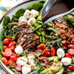 Grilled Caprese Chicken Salad with the most incredible balsamic marinated chicken, fresh tomatoes, creamy mozzarella, grilled asparagus, creamy avocado and crispy bacon all drizzled with Creamy Balsamic Reduction Dressing. Out of this world! #summersalad #springsalad