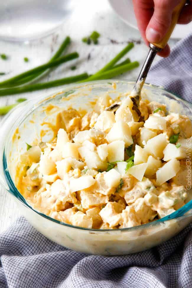 Everyone needs the best potato salad recipe and this is it! so creamy and flavorful and disappears in minutes whenever I take it any where - everyone always asks for the recipe!! showing how to make potato salad by stirring potatoes with dressing