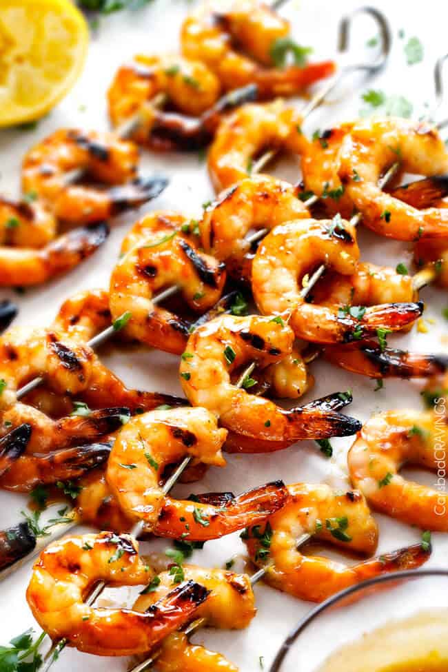 Asian Honey Garlic Shrimp - this is the easiest, most delicious sweet and tangy shrimp and you can make it on the grill or stovetop! and the Honey Lemon Chili Butter Sauce is out of this world! Asian Honey Garlic Shrimp on skewers with honey garlic dip