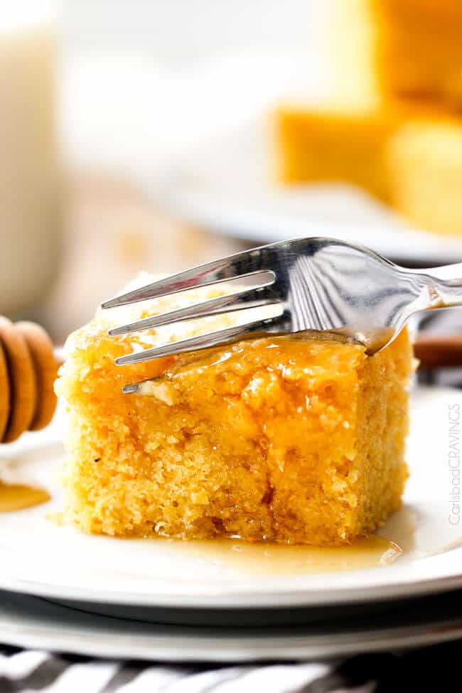 a fork slicing into Sweet Cornbread recipe smothered in honey