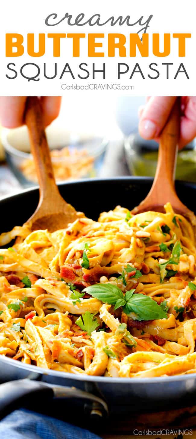 Creamy Butternut Squash Pasta - silky quick and easy pasta that is SO creamy and absolutely addicting! Infused with fresh Parmesan, seasoned to perfection and topped with crispy bacon and toasted pine nuts! #glutenfree #fall two wooden tongs tossing a big bowl of healthy Butternut Squash Pasta