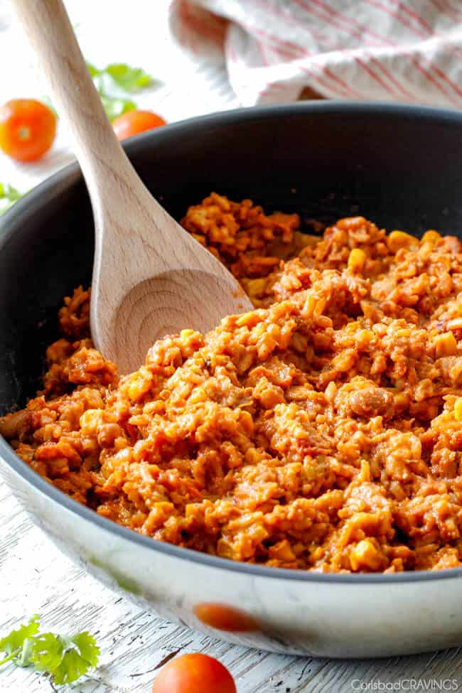 mexican chicken and rice in skillet with wood spoon