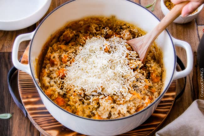 No Babysitting, easy, creamy BAKED Butternut Squash Risotto with Pine Nuts and Pepper Jack! This simple to prepare risotto is wonderfully smooth and creamy, seasoned to perfection and is absolutely fool proof! It makes the most amazing Thanksgiving or holiday side but is easy enough for every day! showing how to make Baked Butternut Squash Risotto by removing theย rice from and adding Parmesan