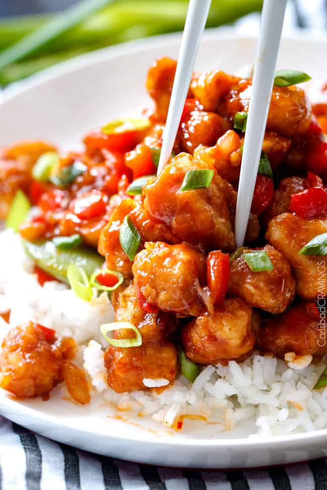 Hoisin Chicken Stir Fry - my family went crazy over this chicken and gobbled it up in minutes! So many layers of flavor - definitely some of the best fakeout takeout I've ever tried! Definitely a keeper! two chopsticks taking a piece of hoisin chicken