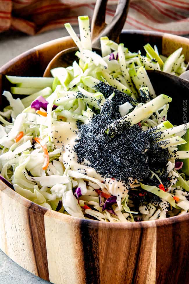 20 Minute Chipotle BBQ Cranberry Turkey Sliders (or chicken!) are a wonderfully delicious way to devour your Thanksgiving turkey leftovers or SO good you will want to make them forever and ever with chicken! And donโt skip the crunchy, sweet and tangy out of this world Apple Poppy Seed Slaw! showing how to make Thanksgiving turkey sliders by tossing coleslaw ingredients in a bowl