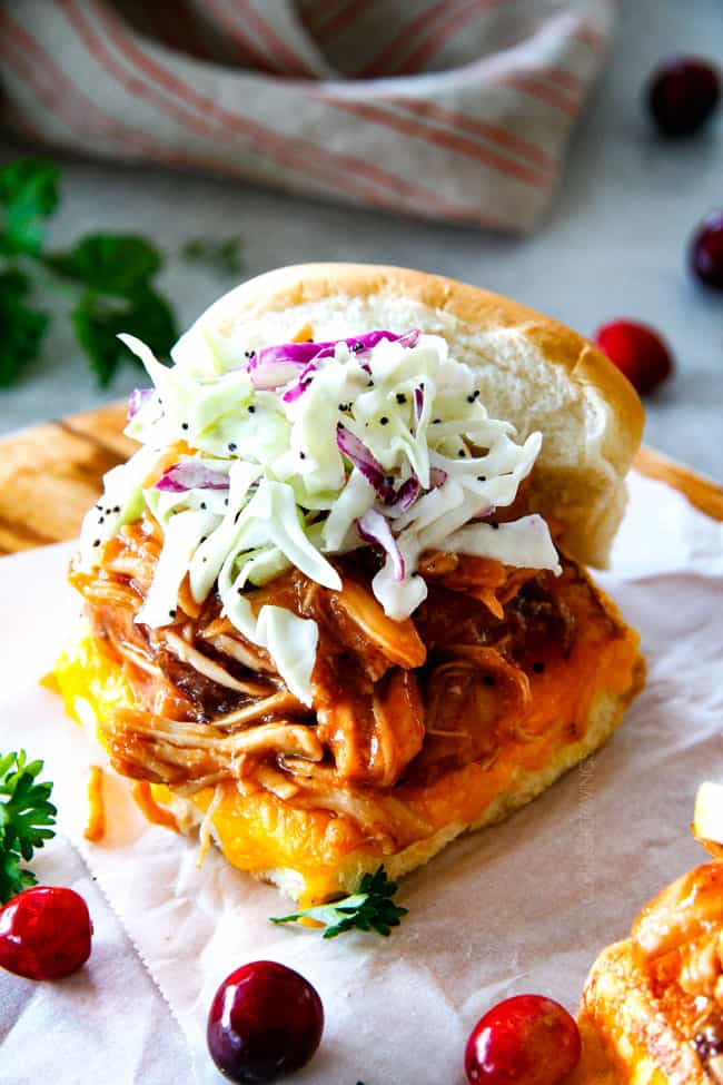 20 Minute Chipotle BBQ Cranberry Turkey Sliders (or chicken!) are a wonderfully delicious way to devour your Thanksgiving turkey leftovers or SO good you will want to make them forever and ever with chicken! And donโt skip the crunchy, sweet and tangy out of this world Apple Poppy Seed Slaw! up close of Thanksgiving pulled turkey sliders with glaze