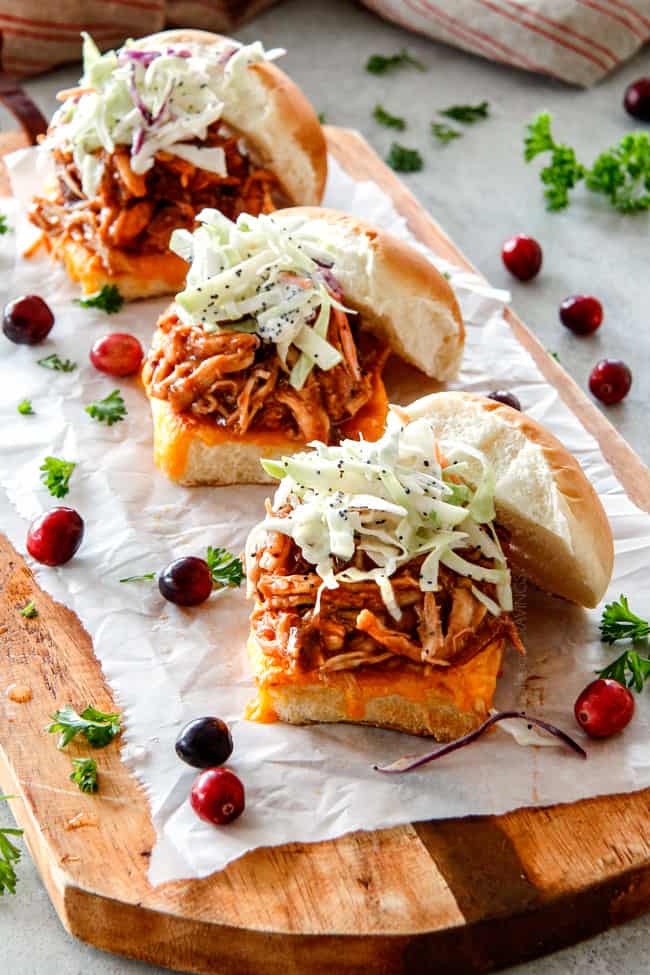 20 Minute Chipotle BBQ Cranberry Turkey Sliders (or chicken!) are a wonderfully delicious way to devour your Thanksgiving turkey leftovers or SO good you will want to make them forever and ever with chicken! And donโt skip the crunchy, sweet and tangy out of this world Apple Poppy Seed Slaw! Baked turkey sliders on a cutting board