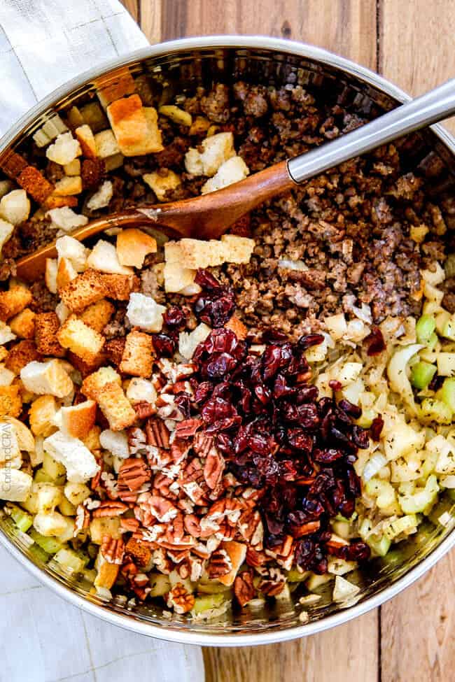 Thanksgiving Cornbread Sausage Stuffing (Dressing) with dried cranberries, apples and pecans is is destined to become your new go-to recipe!! The wonderfully savory, buttery herb infused stuffing is moist, flavorful, easy and absolutely addicting! showing how to make Cornbread Stuffing by mixing cornbread, Italian bread, sausage, apples, onions, pecans in a big bowl