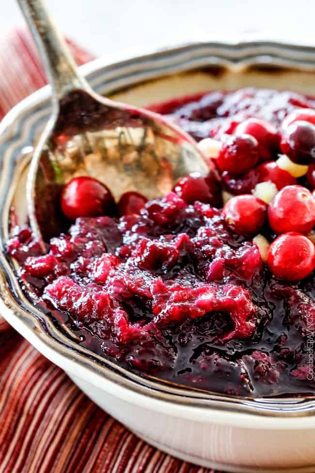 Cooked Pineapple Cranberry Sauce in a bowl with a silver spoon.
