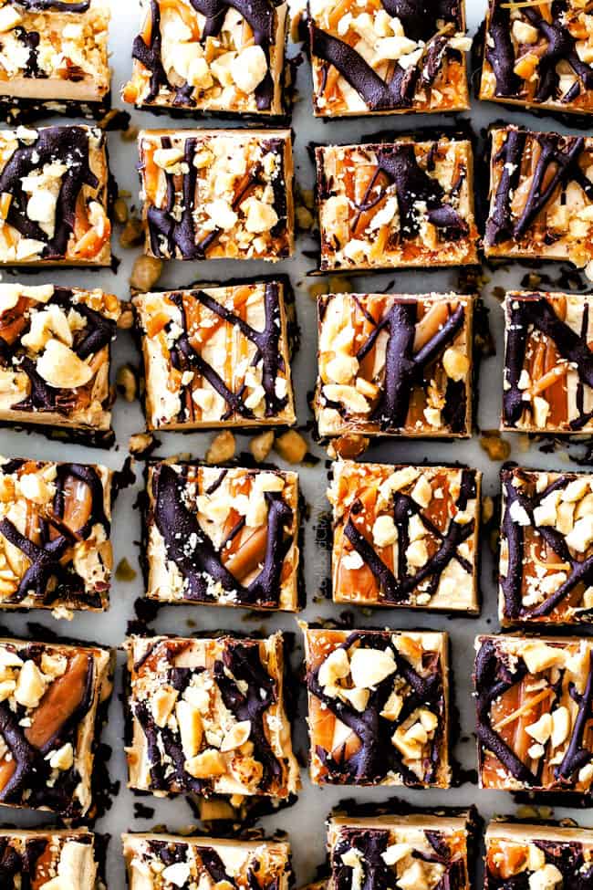 Chocolate Caramel Peanut Butter Fudge in a row on a baking sheet.