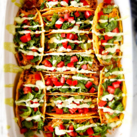 EASY Baked Fiesta Ranch Chicken Tacos piled with refried beans, cheese and the most amazing slow cooker chicken making assembly a snap! My family begs for these tacos weekly! And don't skip the Tomatillo Avocado Ranch - its to die for!