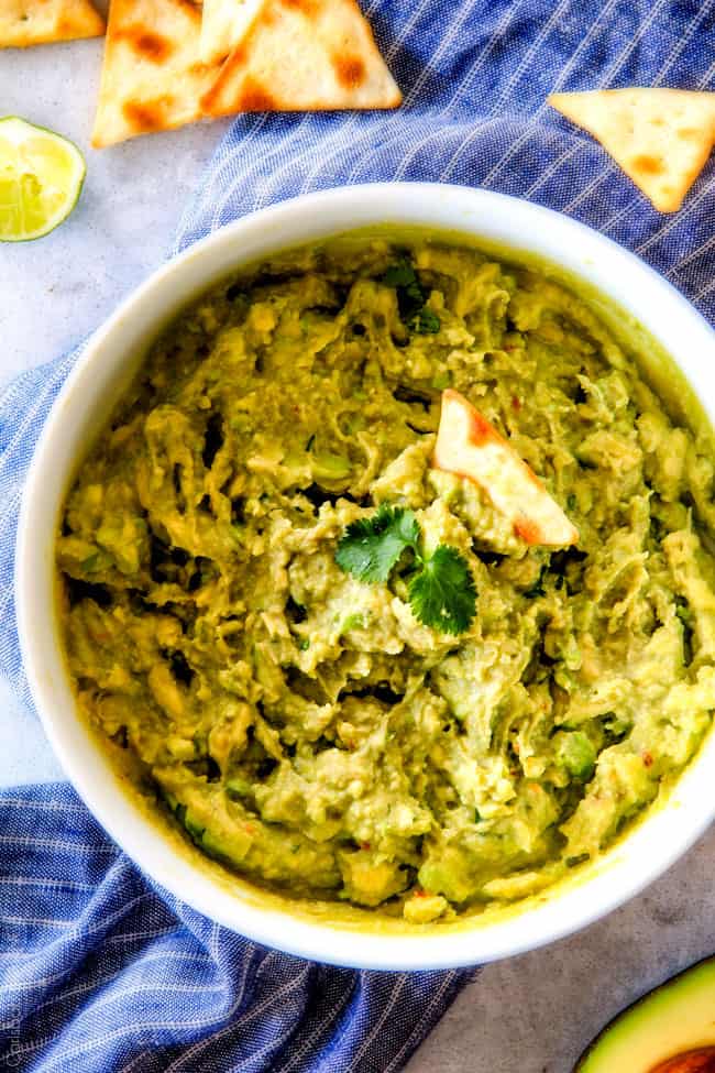 This creamy Avocado Hummus is SO addicting and only 3 ingredients! Its crazy flavorful, healthy and super easy! top view of easy avocado hummus with store bought hummus