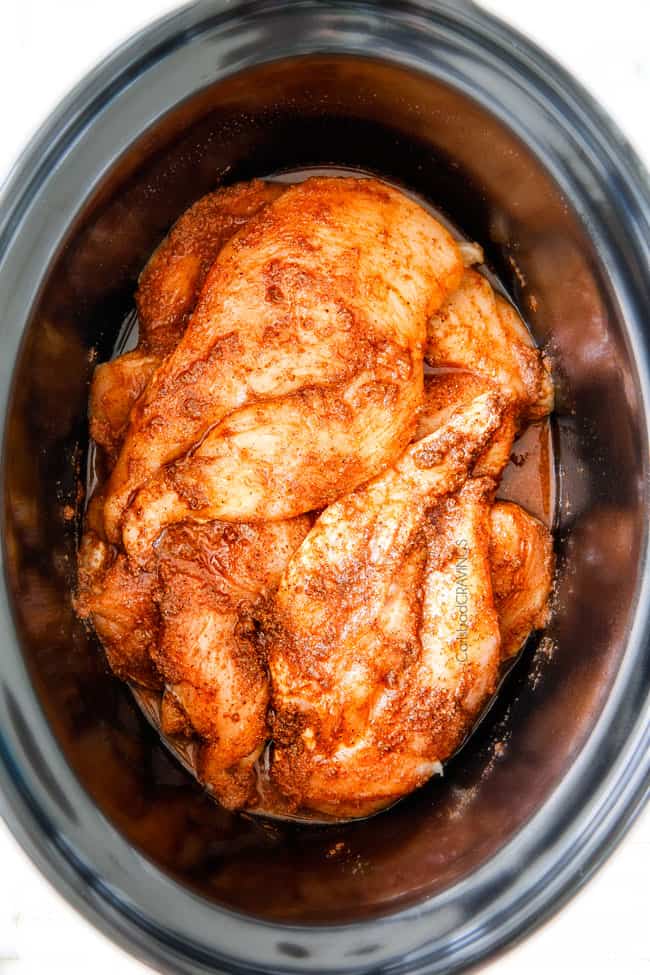 Slow Cooker Fiesta Ranch Cream Cheese Chicken is wonderfully creamy, seasoned to perfection and is as easy as dump and run! It makes the perfect make ahead filling for taquitos, tacos and burritos! showing how to make Cream Cheese Chicken by adding chicken to crockpot