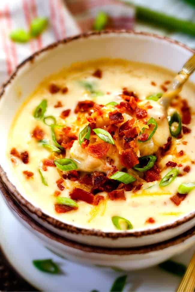 This Skinny Slow Cooker Potato Soup is unbelievably creamy, super flavorful and absolutely the best I've ever tried! and its super easy in the crock pot! a spoonful of thick and creamy skinny crockpot potato soup with cheese, bacon and green onions