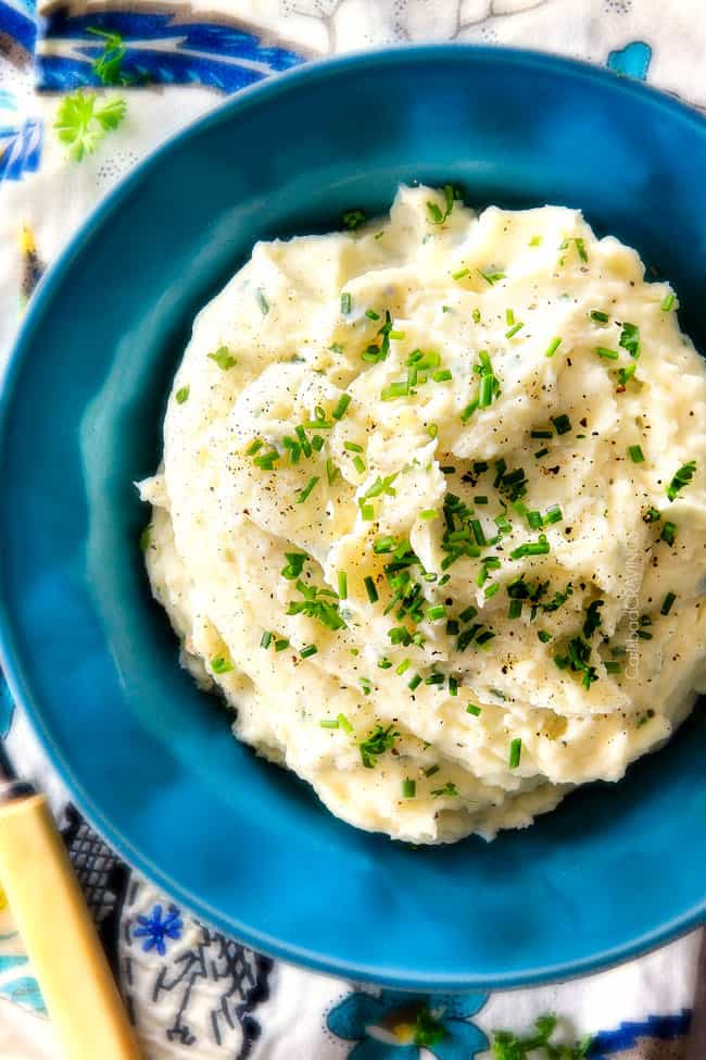 top view of garlic mashed potatoes in a bowl showing how creamy they arer, garlic, and Parmesan! I could eat these all day alone with a spoon - they are incredibly velvety, flavorful and so good everyone will beg you for the recipe!