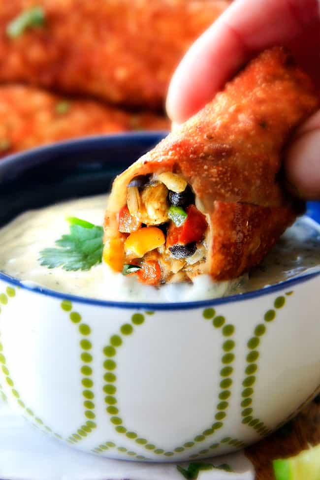 CRISPY Southwest Egg Rolls loaded with Mexican spiced chicken, beans, tomatoes, rice, avocado and cheese! These egg rolls are unreal! So much flavor and texture! And don't skip the Cilantro Lime Ranch Dip - its heaven! dipping Baked Southwest Egg Rolls into Creamy Cilantro Ranch Dip