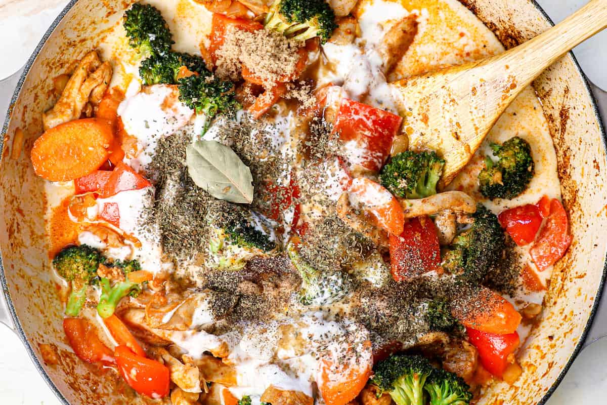 showing how to make curry chicken by adding the coconut milk, fish sauce, soy sauce, lime juice and bay leaf to the chicken and vegetables