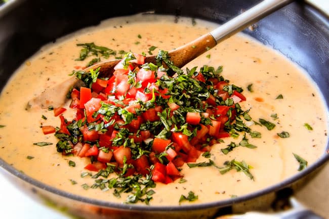 Showing how to make Garlic Mozzarella Margherita Pasta with basil by adding tomatoes.