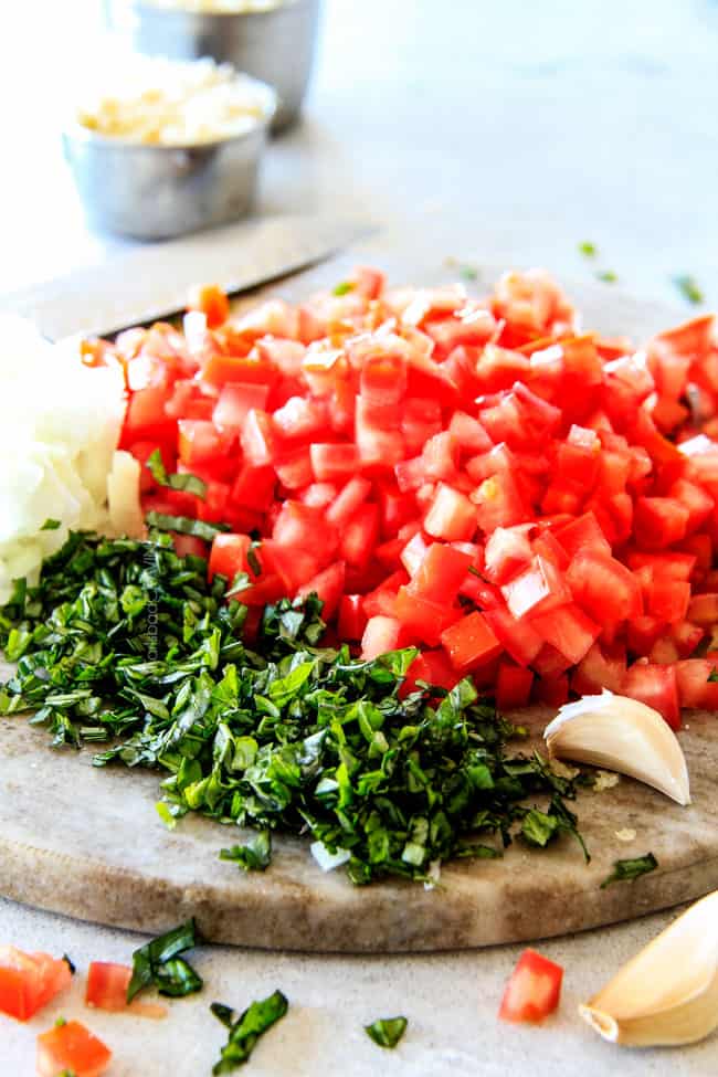 Showing how to make Garlic Mozzarella Margherita Pasta with basil by preparing herbs and vegetables.