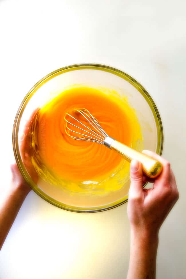 Watermelon Salad with Creamy Citrus Glaze - I took this to a barbecue and it was gone in minutes! Its so cool and refreshing withe the BEST GLAZE and I love the combo of melons, strawberries, bananas, apples and grapes! showing how to make fruit salad dressing for watermelon salad by whisking it in a glass bowl