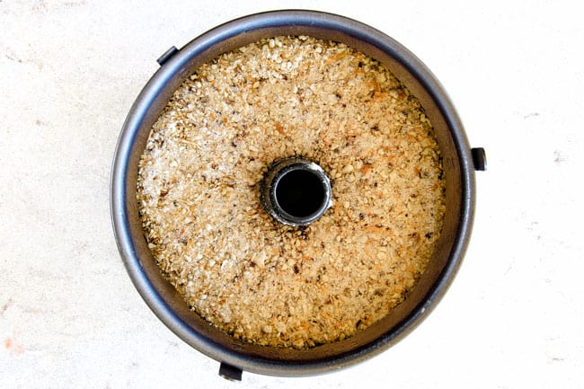 Strawberry Cream Cheese STUFFED Sour Cream Coffee Cake - this is the best strawberry coffee cake ever! the INCREDIBLY creamy cheesecake-like cream cheese filling and strawberries all topped with Coconut Pecan Streusel and Lemon Drizzle is OUT OF THIS WORLD! I can't say enough good things about this coffee cake! showing how to make Cream Cheese Coffee Cake by adding crumb topping on top of cake batter