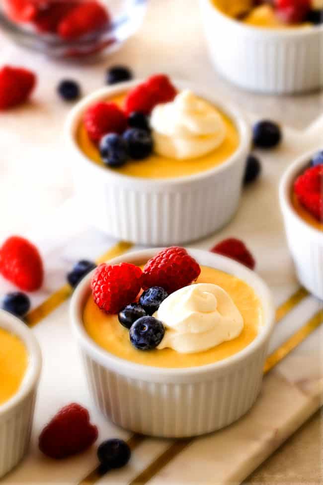 Lemon Pots de Creme with raspberries and blueberries and cream on top.