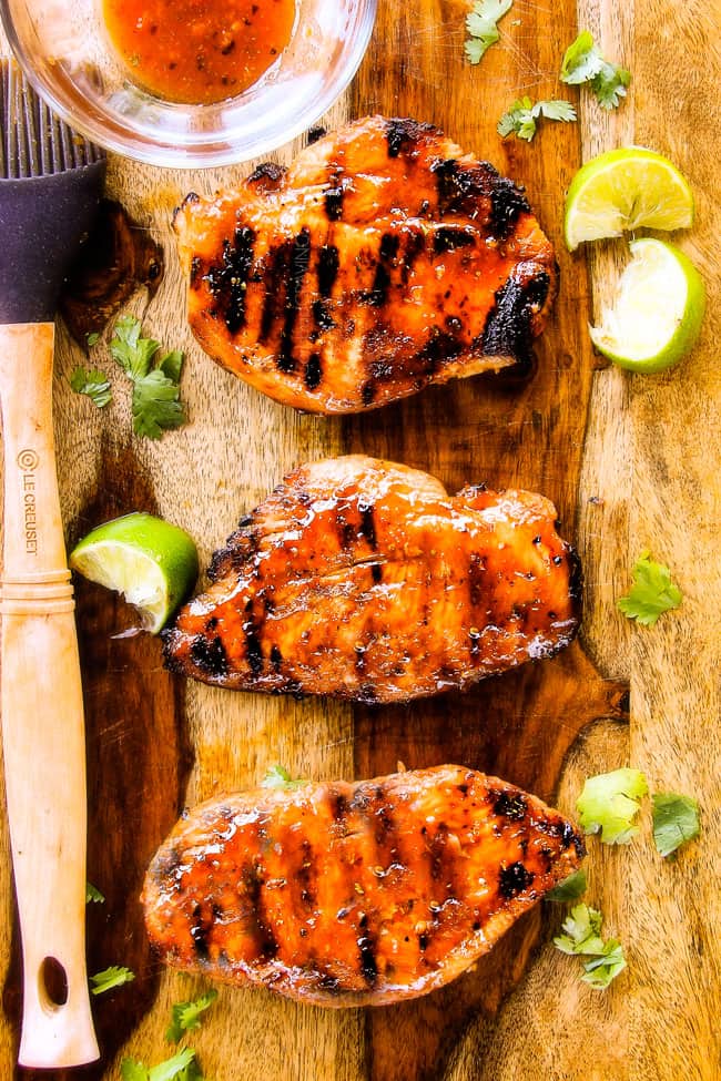 showing how to make chipotle tacos by brushing grilled chicken with reserved marinade