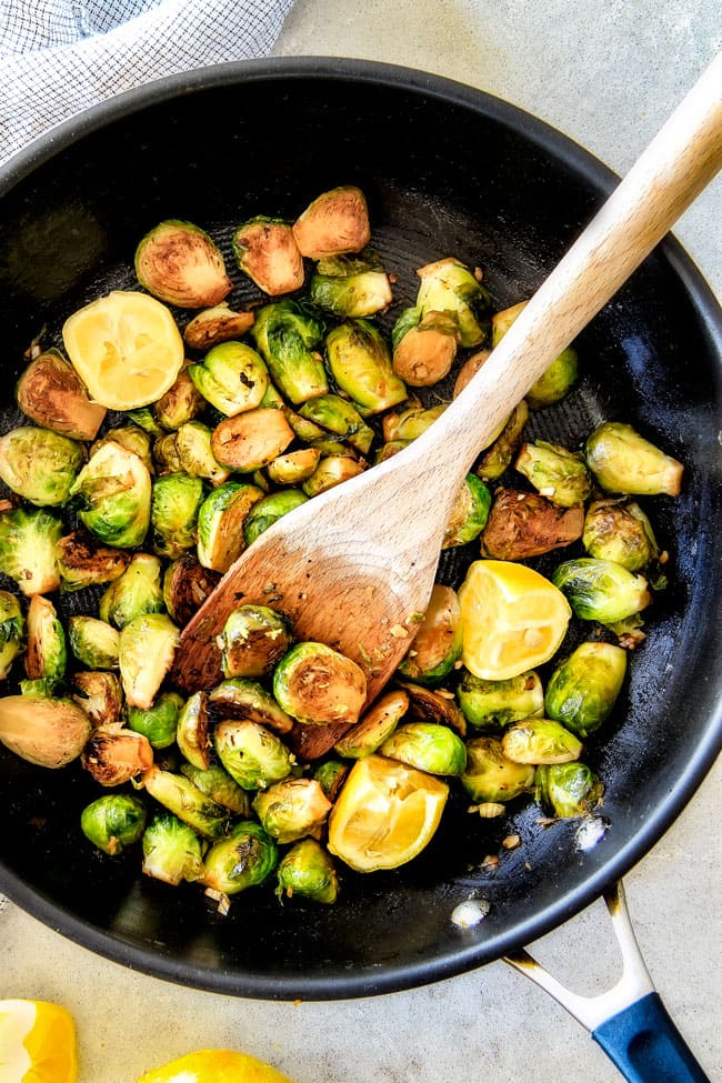 These nutty, caramelized 15 Minute Brussels Sprouts sauteed with garlic, butter and lemon are one of my favorite sides ever and I love the steaming trick for even cooking! showing how to cook Brussels sprouts in a black skillet for Sautéed Brussels Sprouts recipe