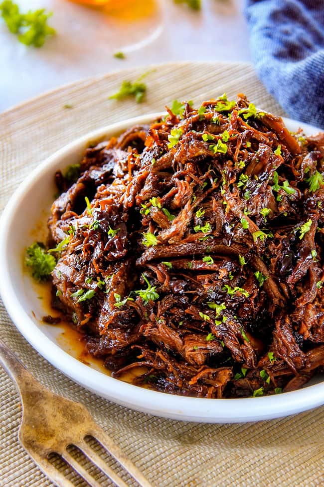 I am obsessed with this sweet and tangy, savory Slow Cooker Honey Balsamic Beef!!! ย It's fall apart tender, crazy juicy, packed with flavor and smothered in the most AMAZING honey balsamic sauce! ย perfect for sandwiches or stand alone delicious with rice and potatoes! best Slow Cooker Roast Beef on a white plate