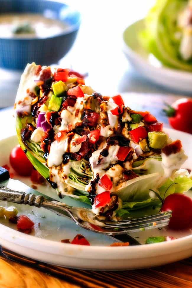 Outback Copycat Wedge Salad smothered in the most amazing creamy, decadent Blue Cheese Ranch and Balsamic Reduction is a flavor/texture lovers dream and crazy easy to make! ย side view of easy Wedge Salad topped with blue cheese dressing