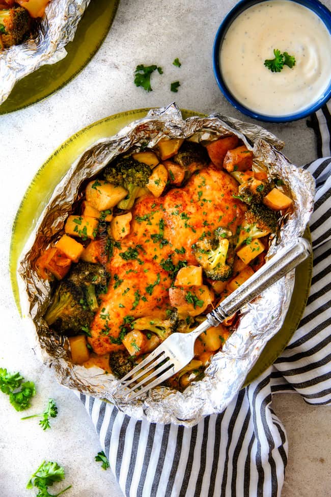 EASY Baked or Grilled Cheesy Buffalo Chicken Foil Packets bursting with juicy chicken and tender, flavorful veggies all smothered in cheddar and dipped in Ranch Crema! ย these are SO addictingly delicious!!! ย ย